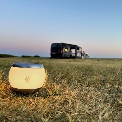 hyggebelysning med solcellelampe og camper i baggrunden